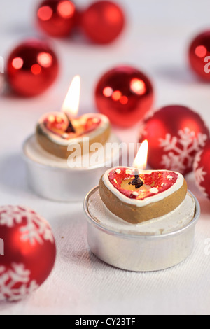 Burning candles in heart shape with Christmas balls and hearts Stock Photo