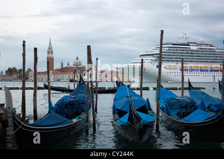 Cruise ship passing along the church of San Giorgio Maggiore with gondolas in the front, view from St Mark's Square, Venice Stock Photo