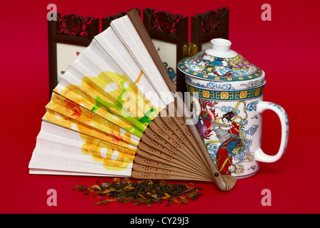 Fan and cup in asian style isolated on red background Stock Photo