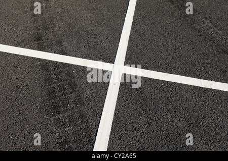 Detail of tire marks and white stripes painted on the road Stock Photo