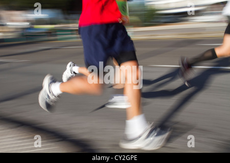 runners legs blurred motion athletes Marathon running on road Stock Photo