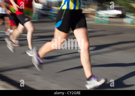 runners legs athletes race Marathon running road blurred motion Stock Photo