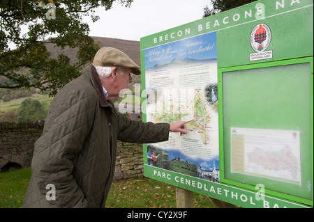 Man reading a Brecon Beacons National Park information board at Llanthony South Wales tourist info notice Stock Photo