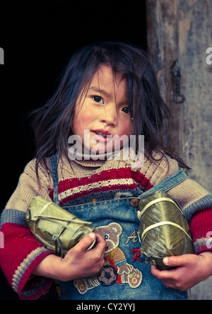 Black Hmong Girl Holding Holding Wrapped Rice Cakes For Tet, Sapa, Vietnam Stock Photo
