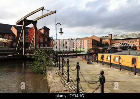 Canalside walkway with wooden cantilever footbridge over the Bridgewater Canal Castlefield Manchester UK. Stock Photo