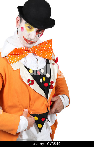 man maked up wearing a grotesque clown costume and a bowler Stock Photo