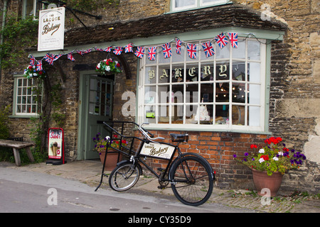 bakery delivery bike parked outside village bakery Lacock Wiltshire England UK Stock Photo