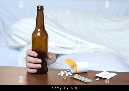 Beer Bottle and various drugs on the table. On the right space for text and graphics. Stock Photo