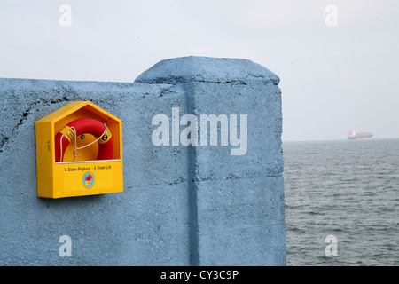 Ringbouy on a wall in Dun Laoghaire Dublin Ireland boat in the distance on the sea Stock Photo