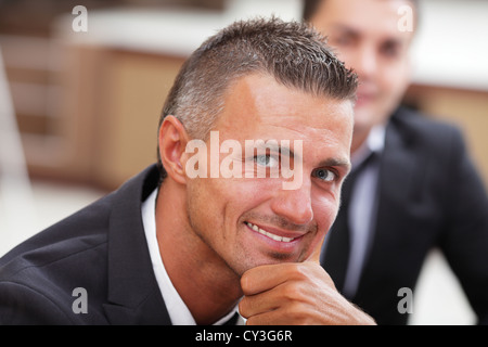 Serious mature businessman in business meeting at office, looking at camera Stock Photo