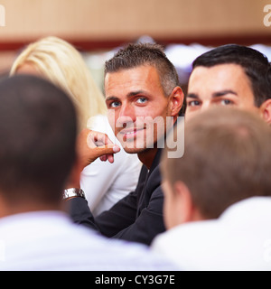 Smiling mature businessman sitting at a business meeting with colleagues Stock Photo