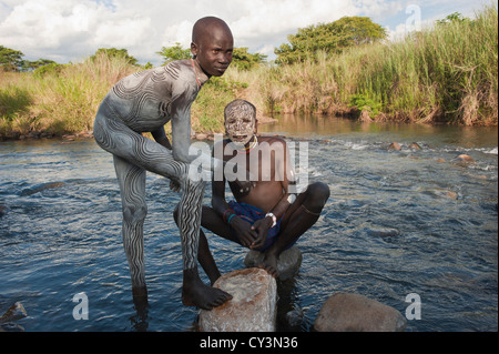 Two Surma men with body paintings in the river, Kibish, Omo River Valley, Ethiopia Stock Photo