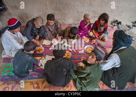 Afghan family having lunch in their mud house Stock Photo