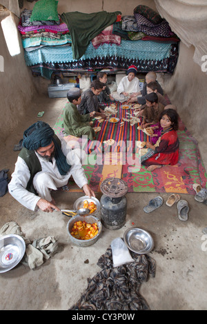 Afghan family having lunch in their mud house Stock Photo