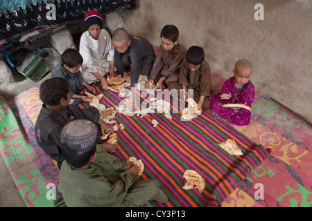 Afghan family having lunch in their mud house Stock Photo