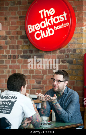 Two men sit and talk in the Breakfast club, a lounge and diner off Hoxton Square. Hackney, London UK Stock Photo