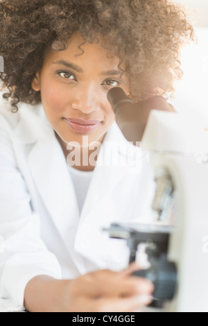 USA, New Jersey, Jersey City, Woman using microscope in laboratory Stock Photo