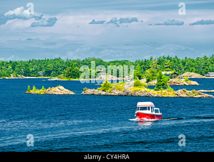 Small boat on lake near island in Georgian Bay, Ontario Canada Stock Photo
