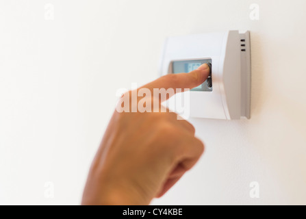 USA, New Jersey, Jersey City, Young woman setting air conditioning Stock Photo