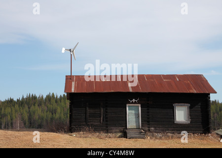 Blockhouse with small wind turbine on the metal clad roof Stock Photo