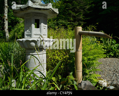 Stone lantern and bamboo water-feature in a Japanese garden in nw. Scotland Stock Photo