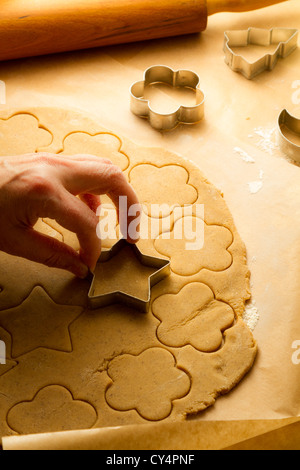 Cutting of Christmas cookies on baking paper Stock Photo