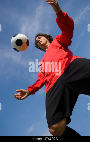 Soccer player controlling ball on his chest on playing field Stock ...