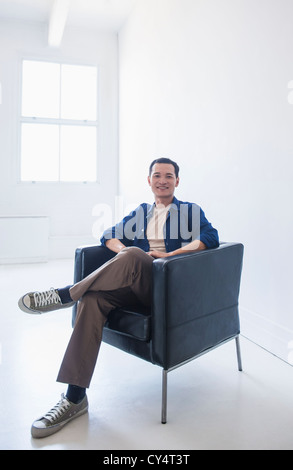 Happy mid adult man sitting in his armchair Stock Photo