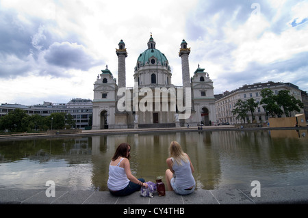 Tourist relaxing by Karls Kirche,  St Charles' Church, in Vienna, Austria. Stock Photo