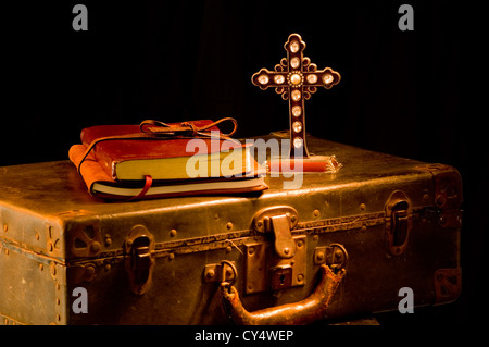 Vintage, antique religious items painted with light. Missionary items including a Bible, journal, suitcase and cross Stock Photo
