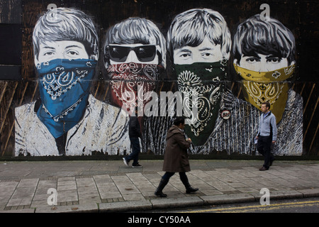 Fab Four art Beatles' faces peer from criminal scarves on street mural by artist Mr Brainwash at the Old Sorting Office, New Oxford Street, London. Mr. Brainwash is the moniker of Los Angeles-based filmmaker and Pop artist Thierry Guetta. Stock Photo