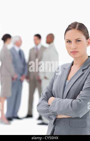 Saleswoman with folded arms and colleagues behind her Stock Photo