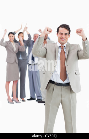 Smiling businessman with cheering team behind him Stock Photo - Alamy