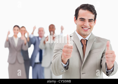 Salesman with team behind him giving thumbs up Stock Photo