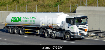 Asda supermarket fuel delivery tanker behind Scania truck on motorway Stock Photo