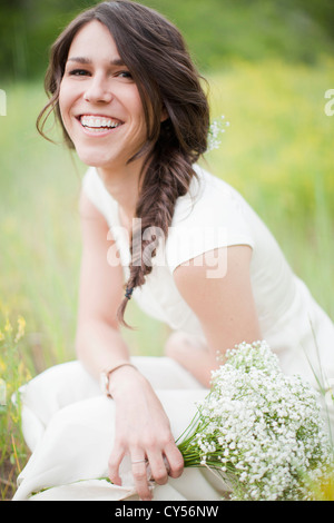 USA, Utah, Salt Lake City, Portrait of young smiling woman holding flowers Stock Photo