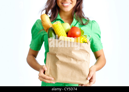 Image of paper packet full of different fruits and vegetables held by female Stock Photo