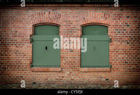 window in the brick wall and old armored steel shutters closed Stock Photo