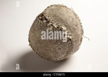 An old battered baseball sits on a white background. Stock Photo