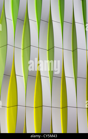 Detail of a modern facade with curved elements in silver color, green and yellow Stock Photo