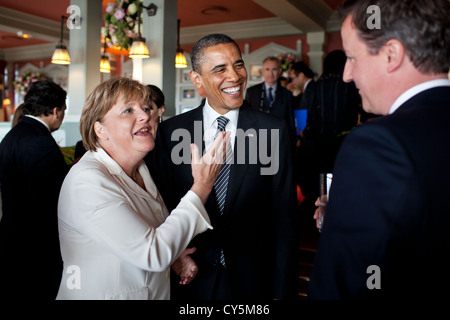 US President Barack Obama talks with German Chancellor Angela Merkel and British Prime Minister David Cameron before the start of the working G8 dinner May 26, 2011 in Deauville, France. Stock Photo