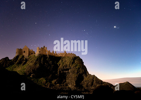 Dunluce Castle captured at night under moonlight.