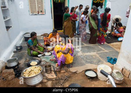 Indian women and girls making sweet jaggery filled chapathi for Dasara festival in a rural Indian village. Andhra Pradesh, India Stock Photo