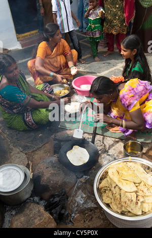 Indian women and girls making sweet jaggery filled chapathi for Dasara festival in a rural Indian village. Andhra Pradesh, India Stock Photo