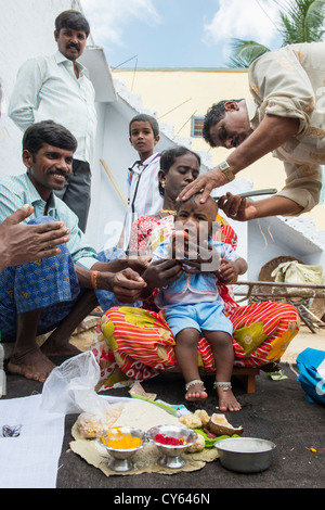 Indian baby hair cutting ritual / puja in a rural indian village. Andhra Pradesh. India Stock Photo