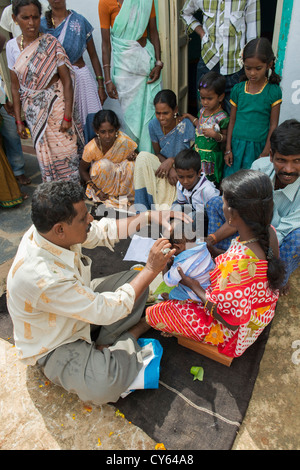 Indian baby hair cutting ritual / puja in a rural indian village. Andhra Pradesh. India Stock Photo