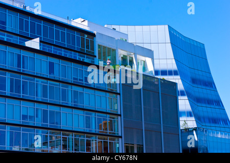 A lone man stands on the balcony of an apartment building next to the Frank Gehry designed IAC building seen from the High Line. Stock Photo