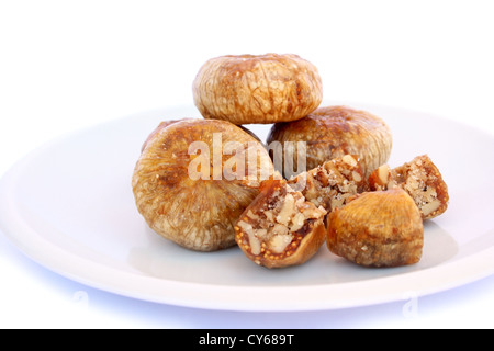 Dried figs stuffed with nuts in plate isolated on white background. Stock Photo