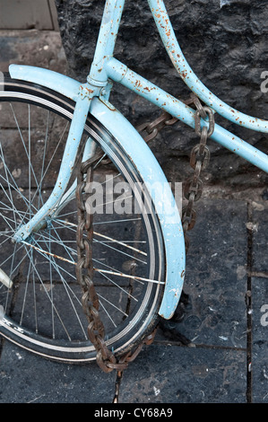A heavy steel chain secures a bicycle on the street in Amsterdam, the Netherlands Stock Photo