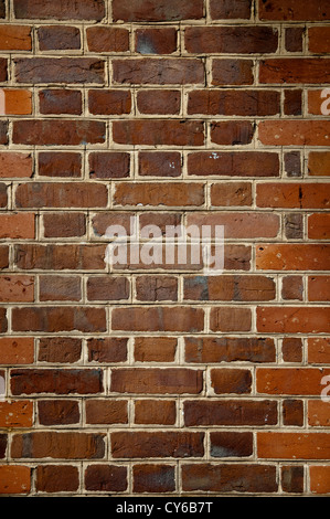 Close up image of Orange and brown brick wall. concrete seperation between each brick is visible Stock Photo